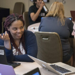 Fellows discussing work together on laptops